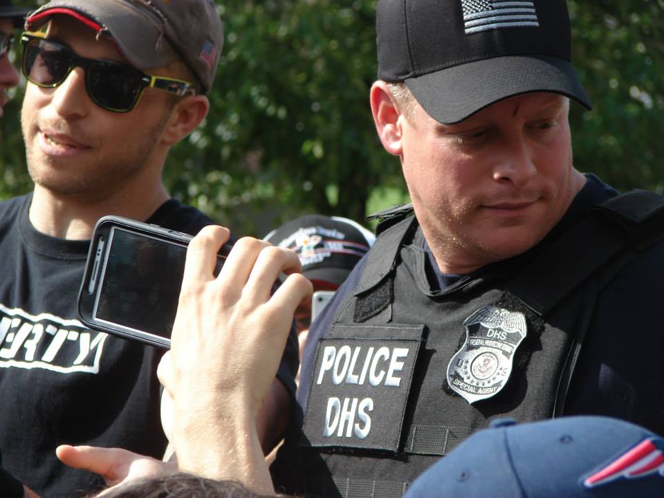 A DHS officer using his smartphone to record Adam Kokesh speaking in the chaotic aftermath of 4:20 at Smokedown 6