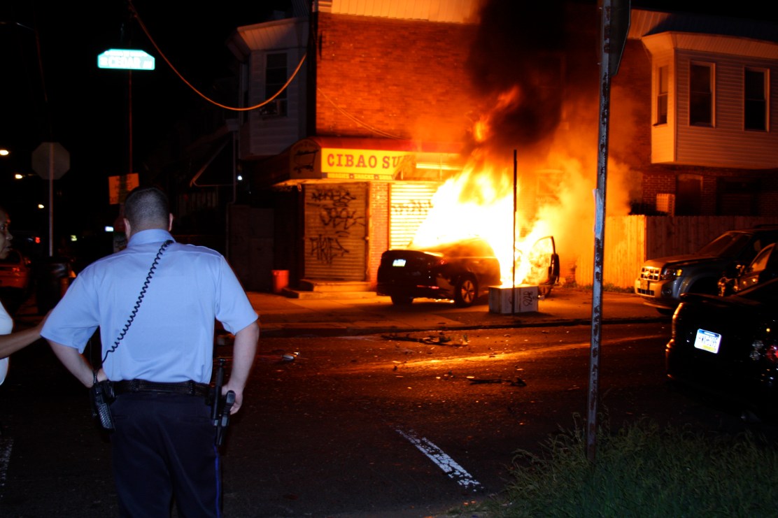 A Philly Police officer arrived on scene first. He threatened to arrest the photographer "for his own safety" when he attempted to approach for a better view. Photo by Kit Friday 