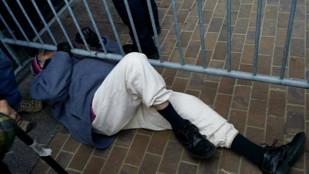 Rabbi Arthur Wasskow climbs underneath a barricade to join Keystone Pipeline protesters outside the federal building in Philadelphia. Photo: Sean Damon