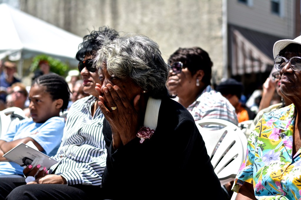 A former 3711 Melon Street resident watches as her old home is demolished.