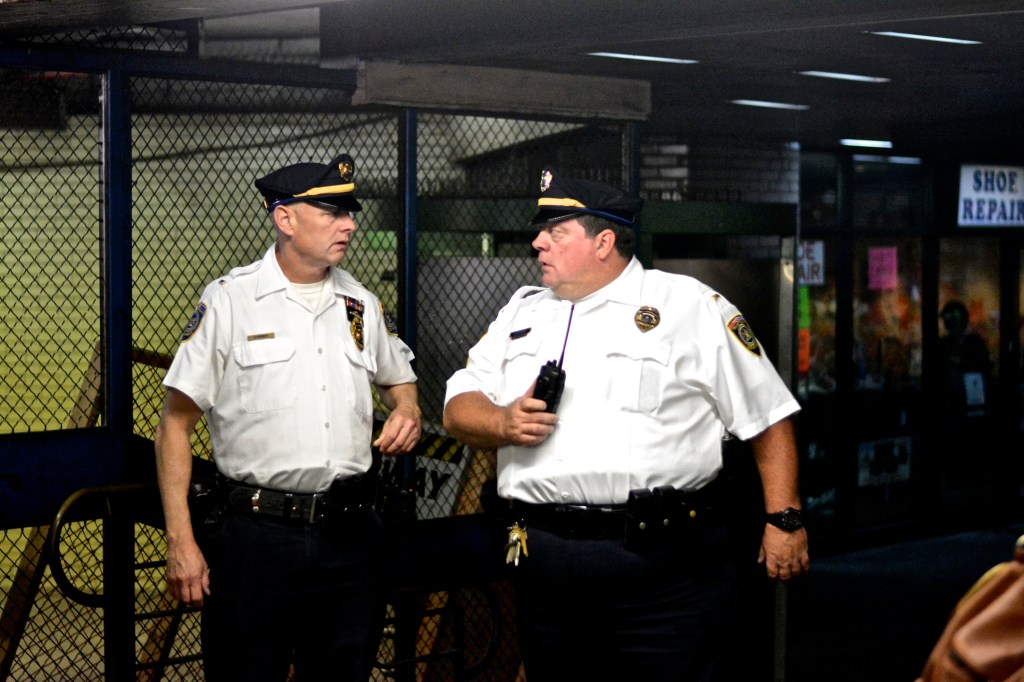 Two SEPTA officer discuss and watch protesters. ( Photo By Joshua Albert)