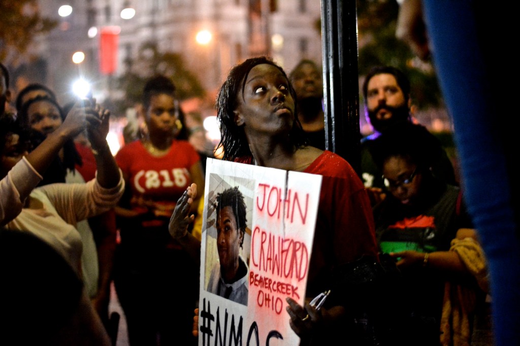 A protester listens to speaker. ( Photo By Joshua Albert)
