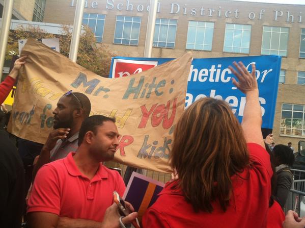 PFT members raise their banner in front of hired anti-union demonstrators. Photo: Regina Medina/Philly Daily News